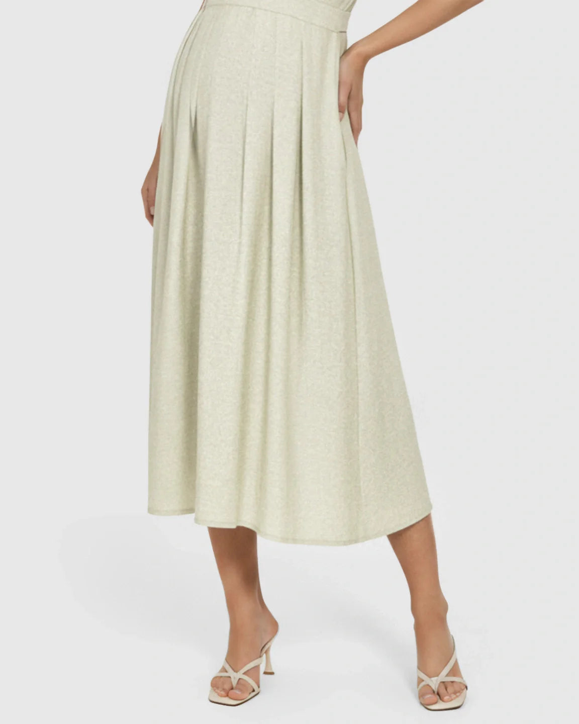 Light green A-line maternity midi dress with pleated skirt, shown on a model wearing white heels.
