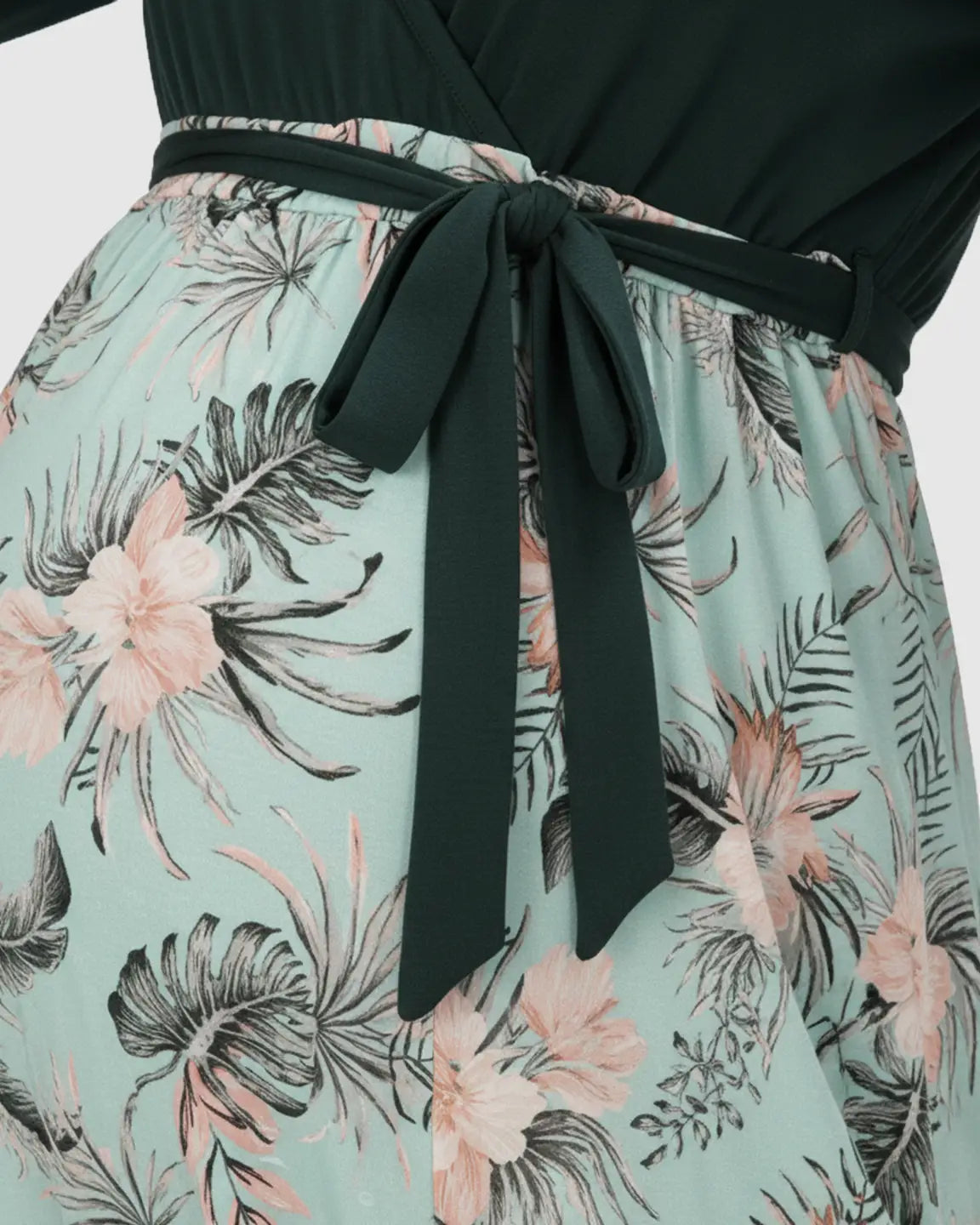Deep green V-neck maternity midi dress with a flowing floral skirt and flexible tie waist.