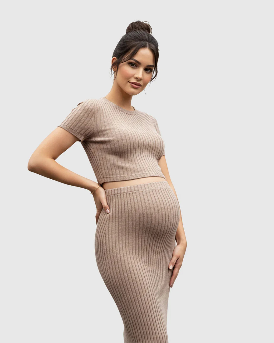 Maternity model in a beige ribbed crop top and side-slit bodycon skirt set, showcasing a comfortable fit.