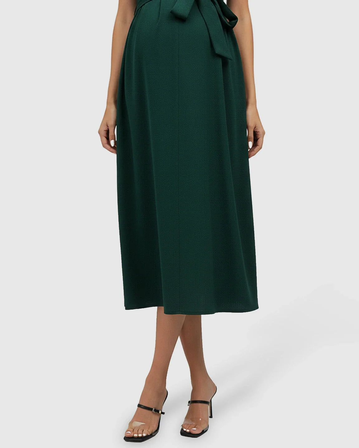 Dark green tie-waist V-neck maternity midi dress, flowing over a pregnant belly, with black heels.