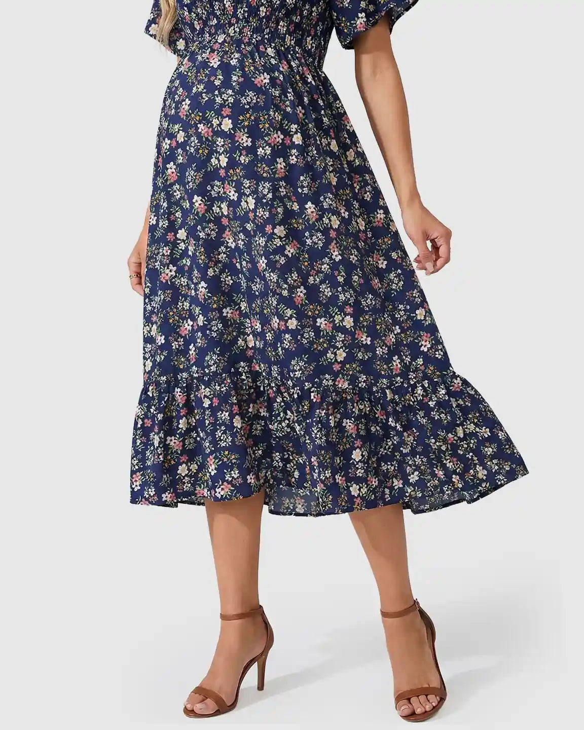 Navy floral flutter-sleeve smocked maternity midi dress with tiered skirt and brown heels.