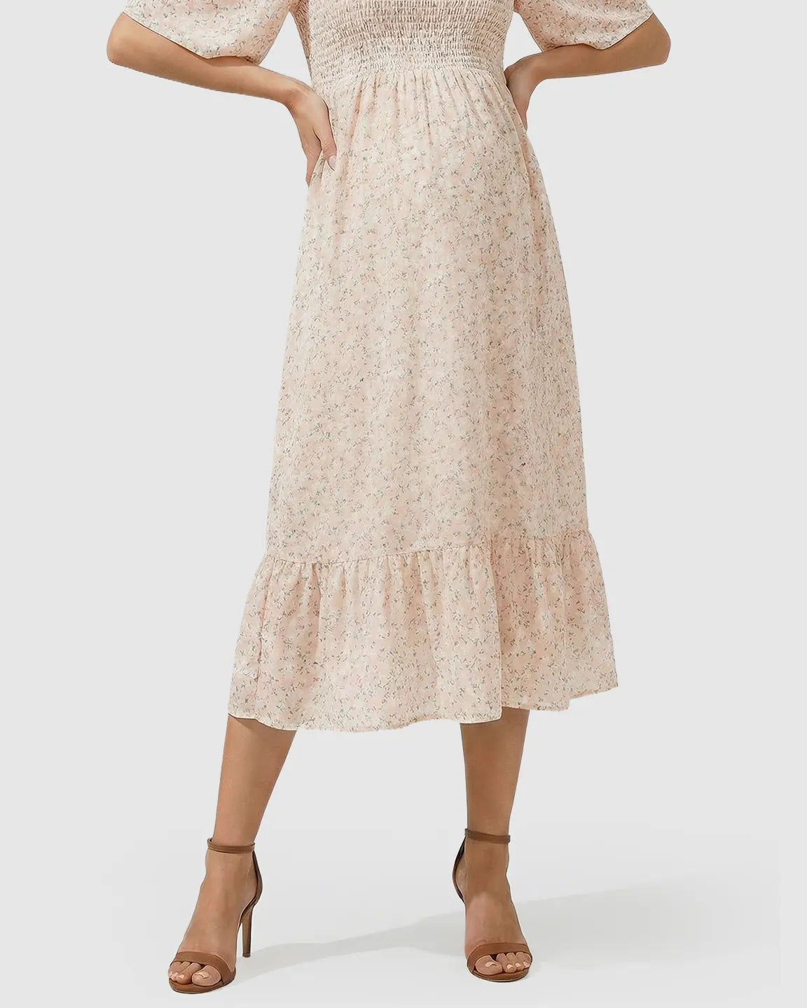 Light pink floral flutter-sleeve smocked maternity midi dress with tiered skirt.