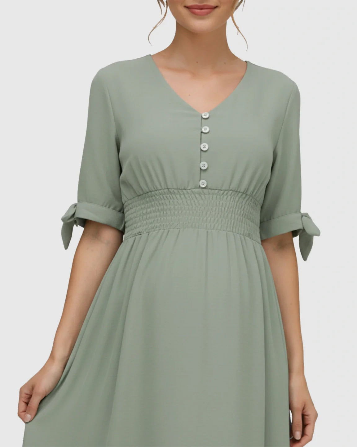 Mint green V-neck empire waist maternity maxi dress with button details and tied short sleeves.