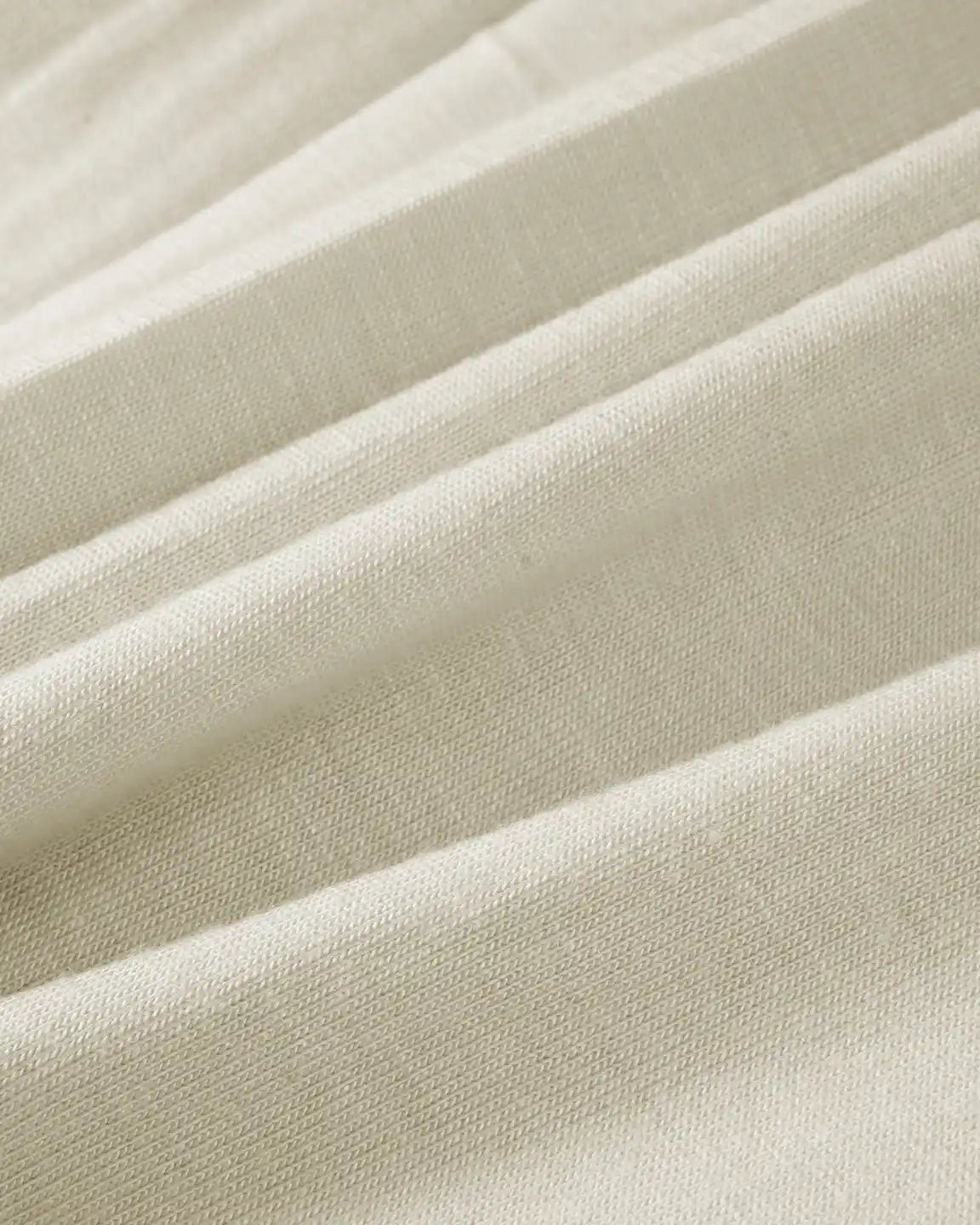 Close-up of soft, stretchy beige fabric with gentle drapes, ideal for a maternity nursing maxi dress.