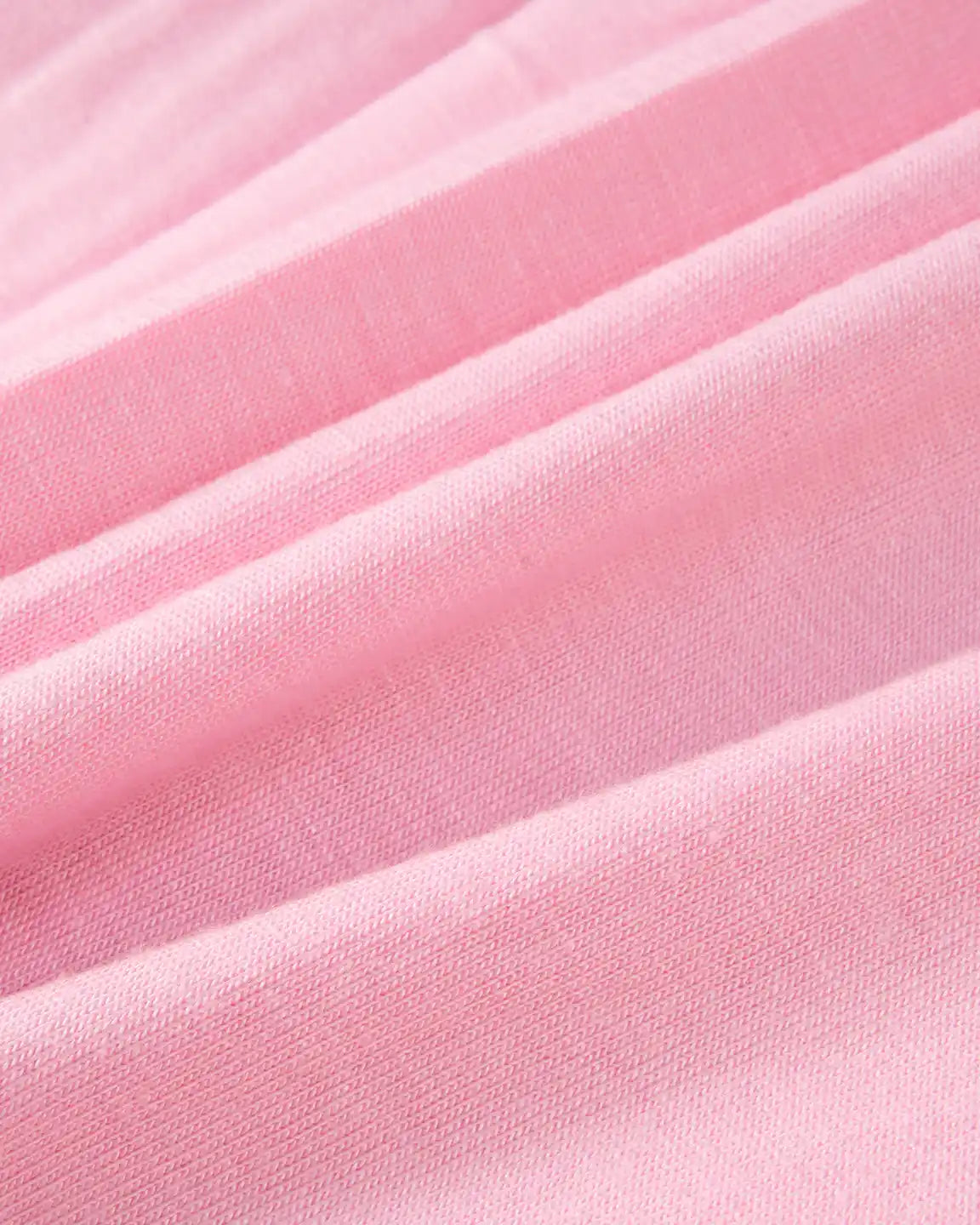 Close-up of soft, draped pink fabric, likely a stretchy jersey, for a Bump Society nursing maxi dress.