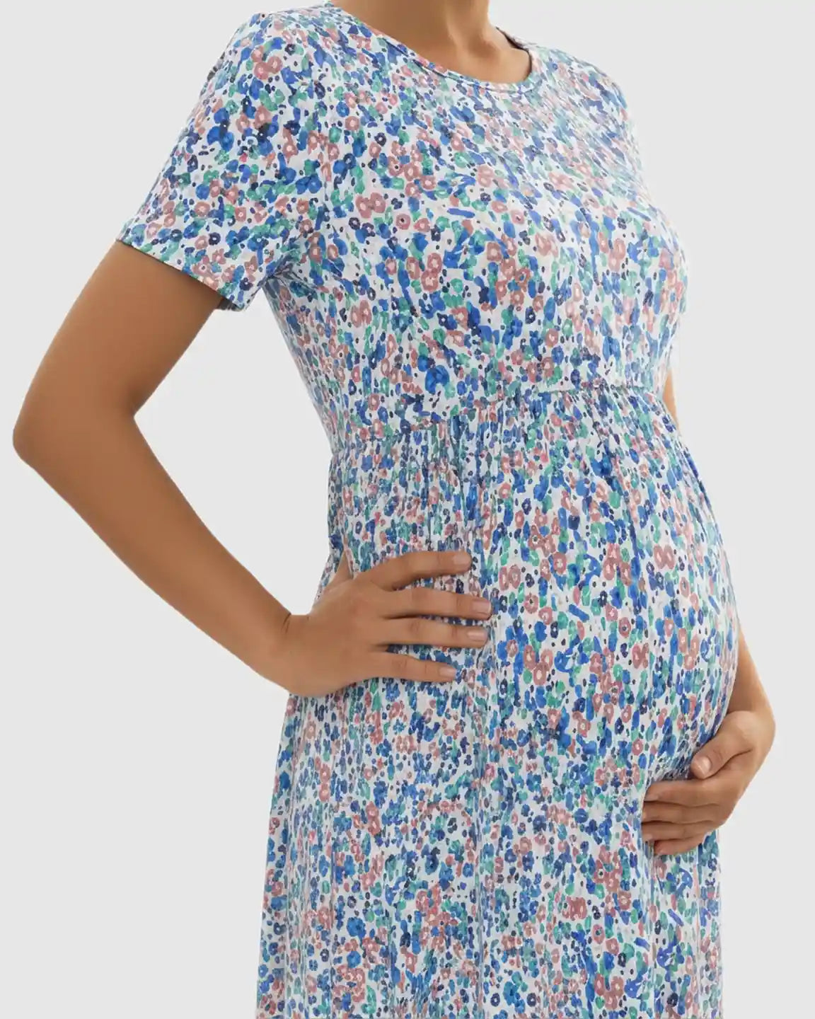 Maternity maxi dress with short sleeves, round neckline, and flowing blue, pink, and green floral chiffon skirt.