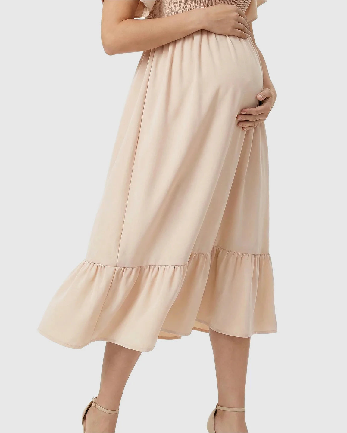 Peach flutter-sleeve smocked maternity midi dress with tiered skirt, worn by an expecting mom.