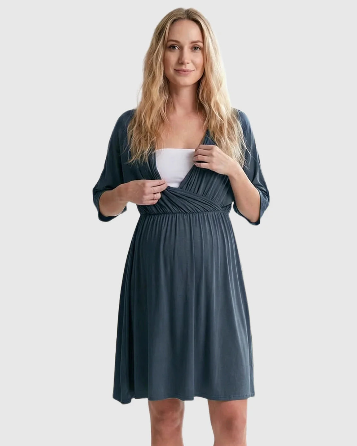 Blonde woman in a slate blue cross-front maternity midi dress with 3/4 sleeves, showing nursing access.