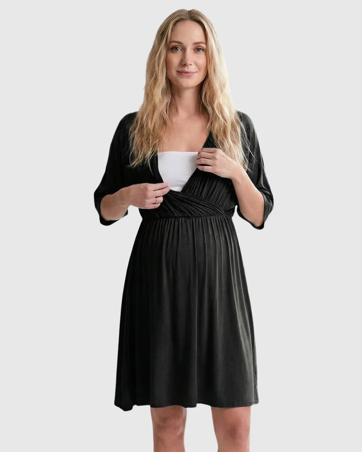 Blonde woman in a black cross-front maternity midi dress with 3/4 sleeves, showing nursing access.