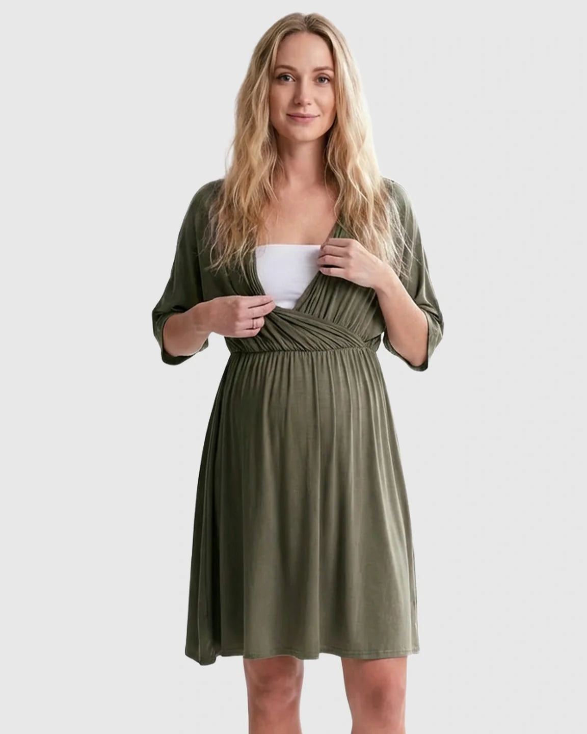 Blonde woman in an olive green cross-front maternity midi dress with 3/4 sleeves, showing nursing access.