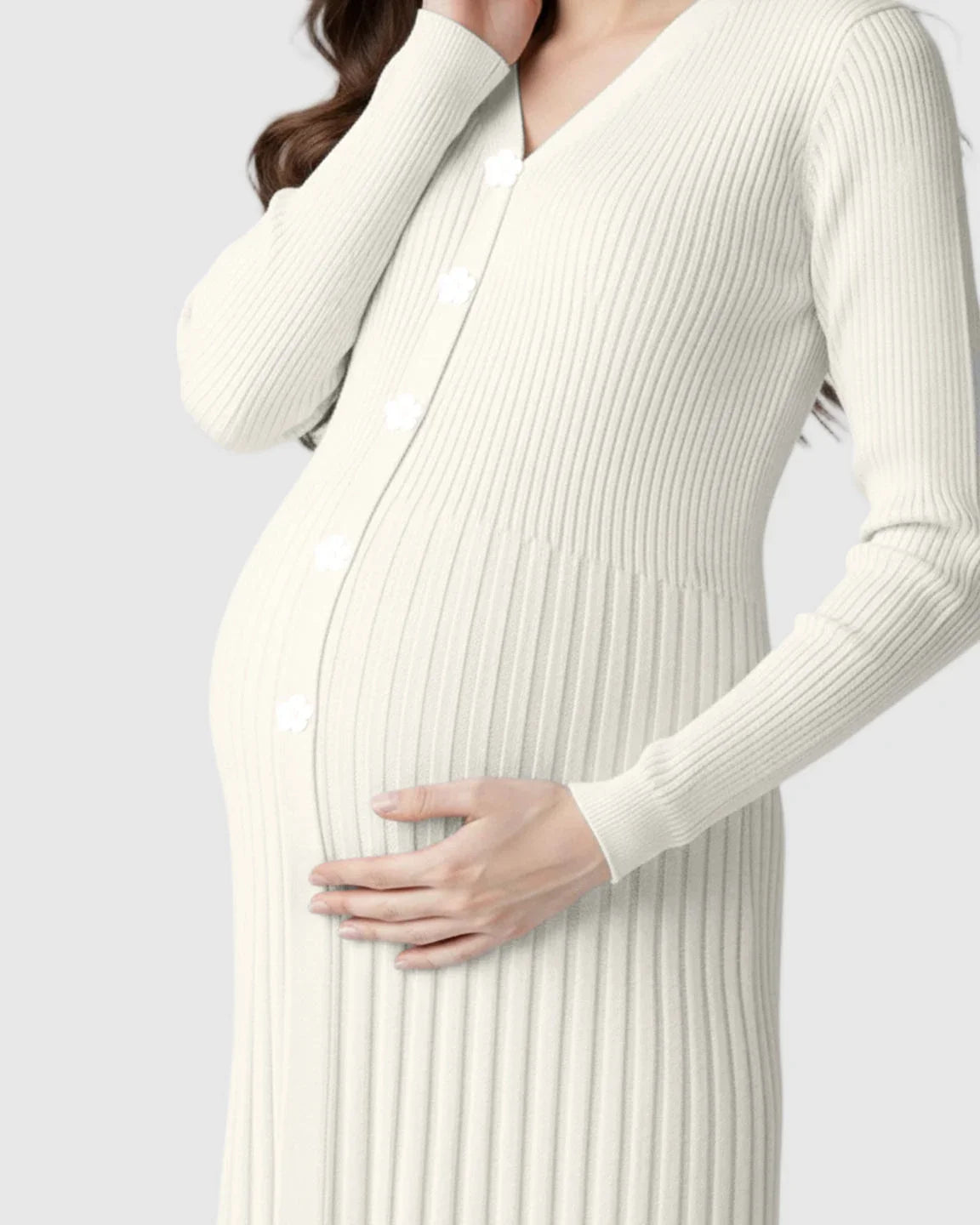 Pregnant woman in an ivory ribbed knit maternity midi dress with long sleeves and white flower buttons.