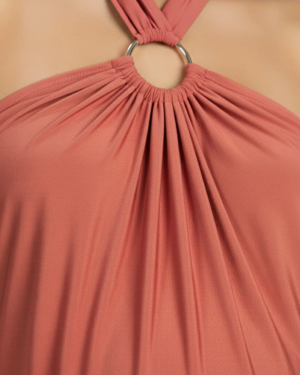 Close-up of a terracotta backless halter neck chiffon maternity maxi dress with a silver O-ring detail.