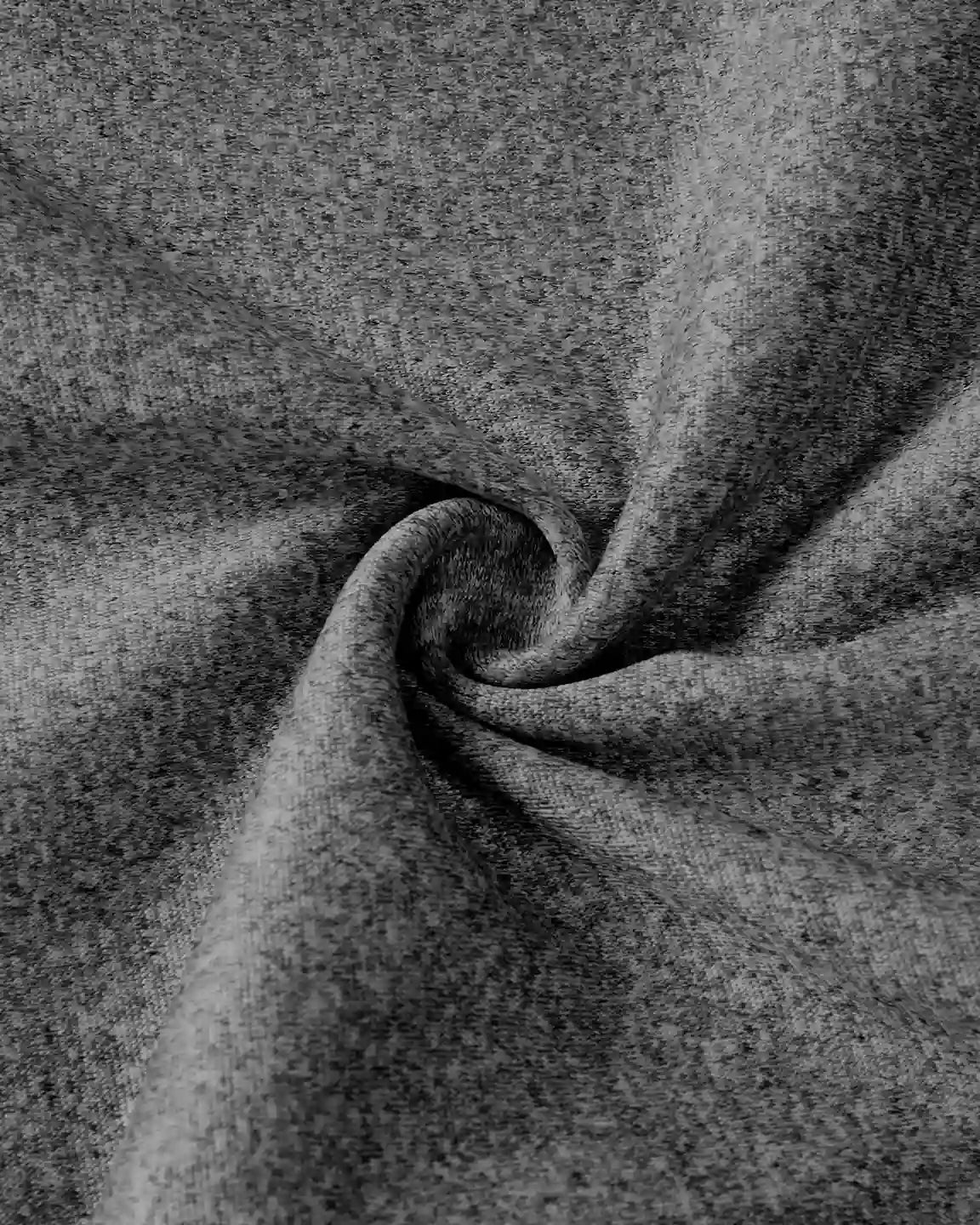 Close-up of dark gray heathered knit fabric, soft and stretchy, with a gentle swirl.