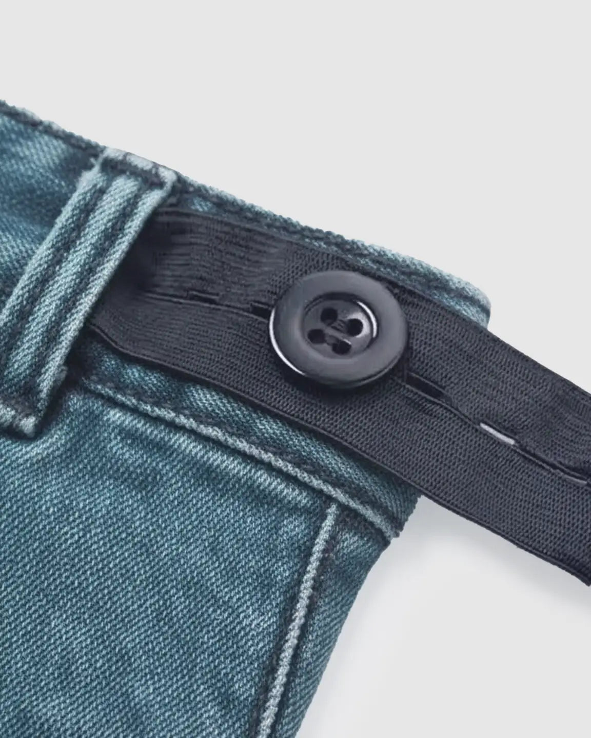 Close-up of dark wash maternity jeans with adjustable black elastic waistband and button.