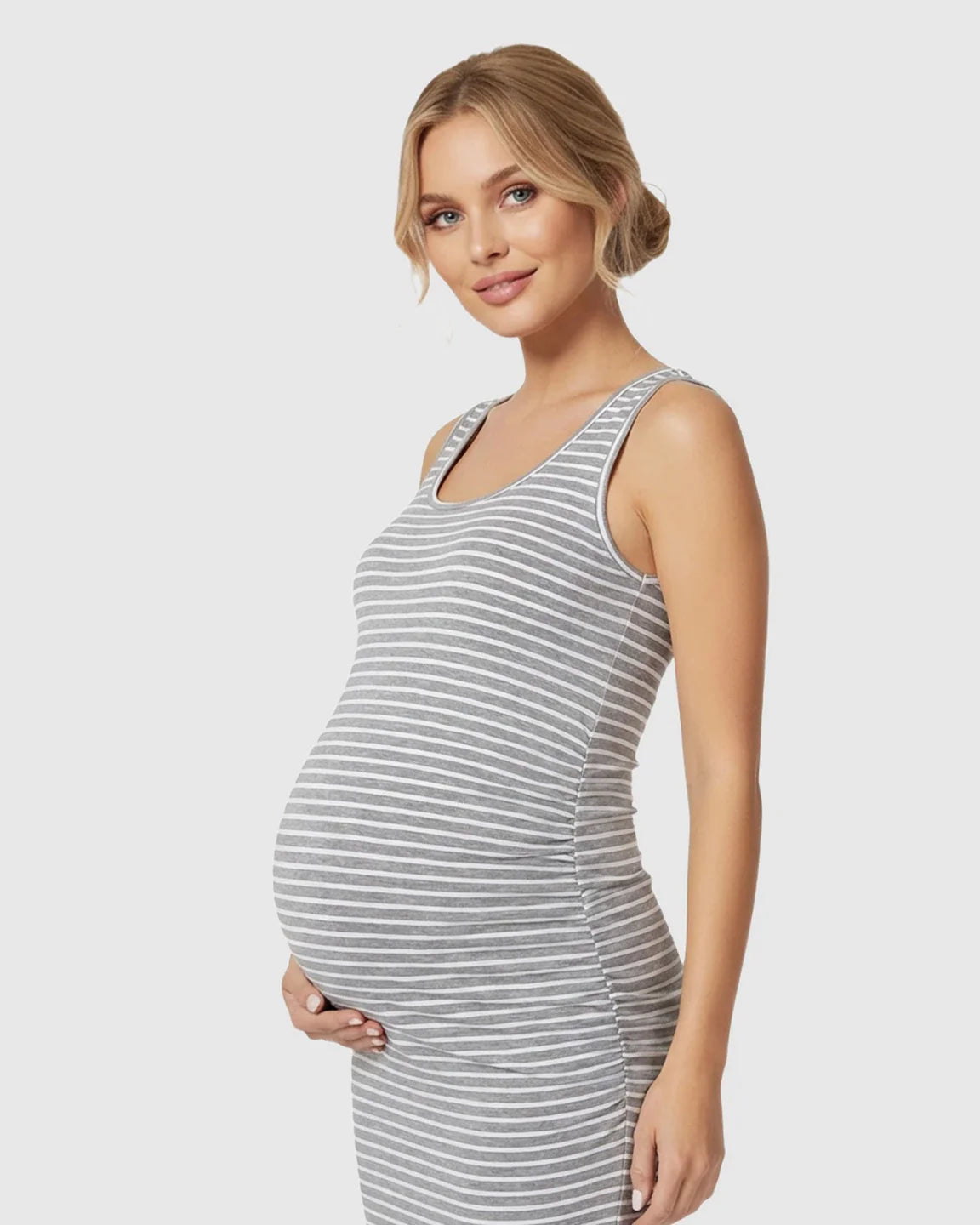 Pregnant woman in a grey and white striped sleeveless bodycon maternity dress with side pleats.