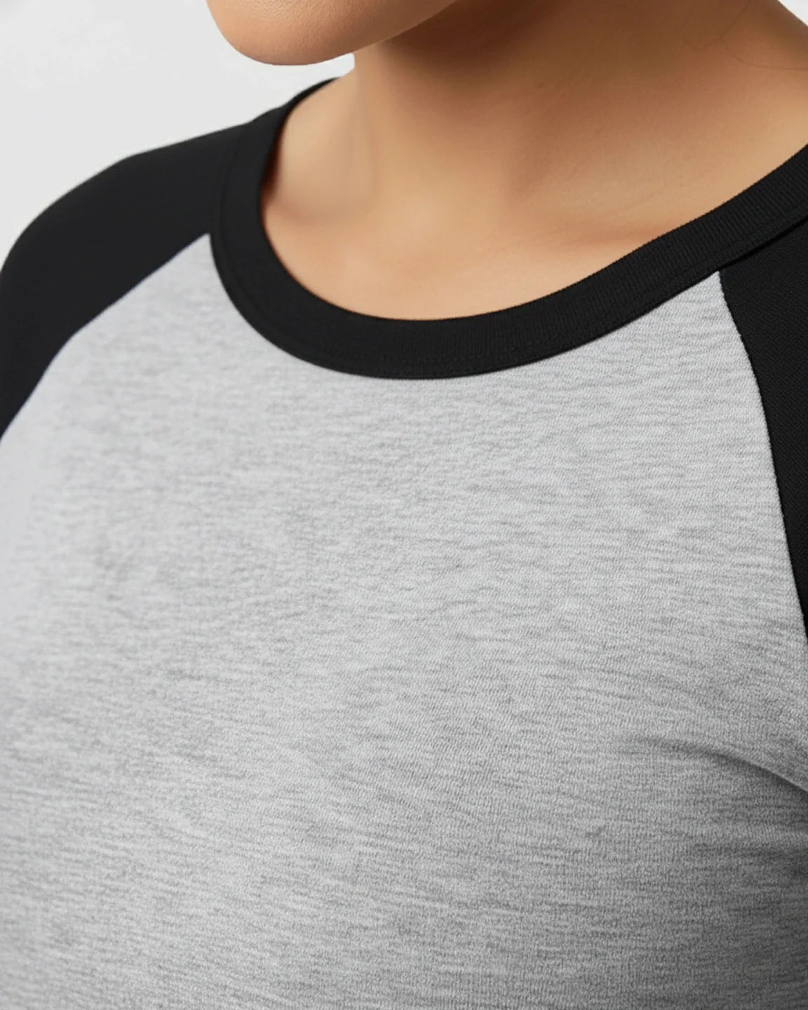 Close-up of a gray and black raglan sleeve maternity top with a round neckline, made from smooth, high-elastic polyester.