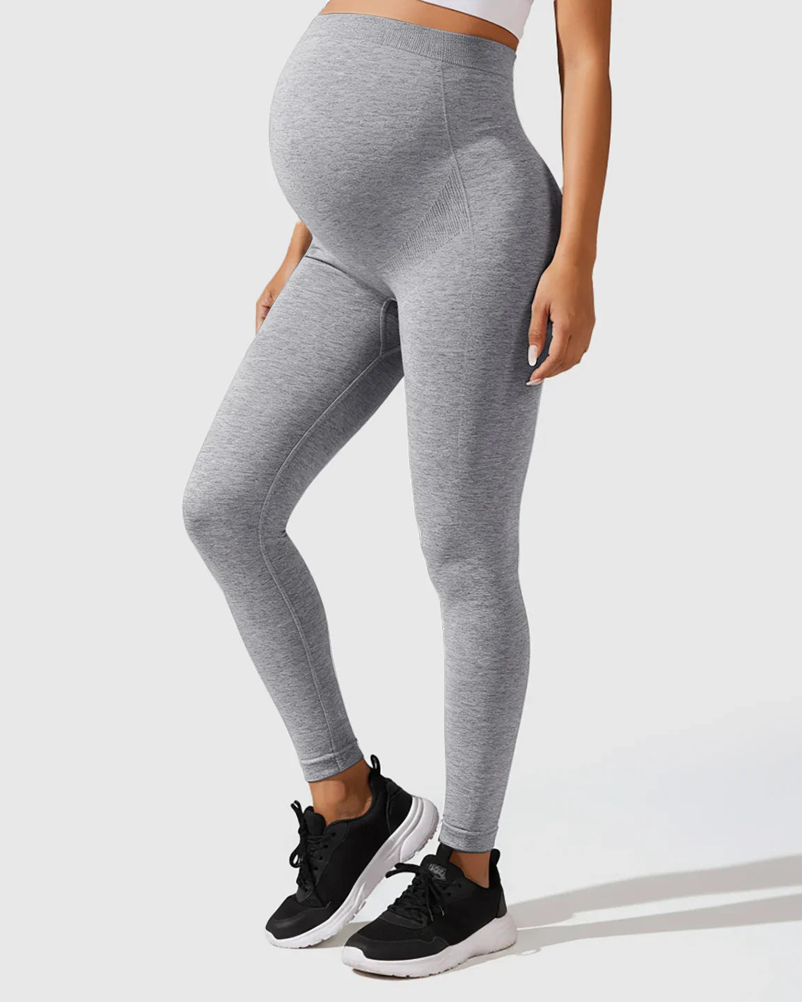 Seamless gray M-shape maternity leggings with full-belly support, worn by a pregnant model.