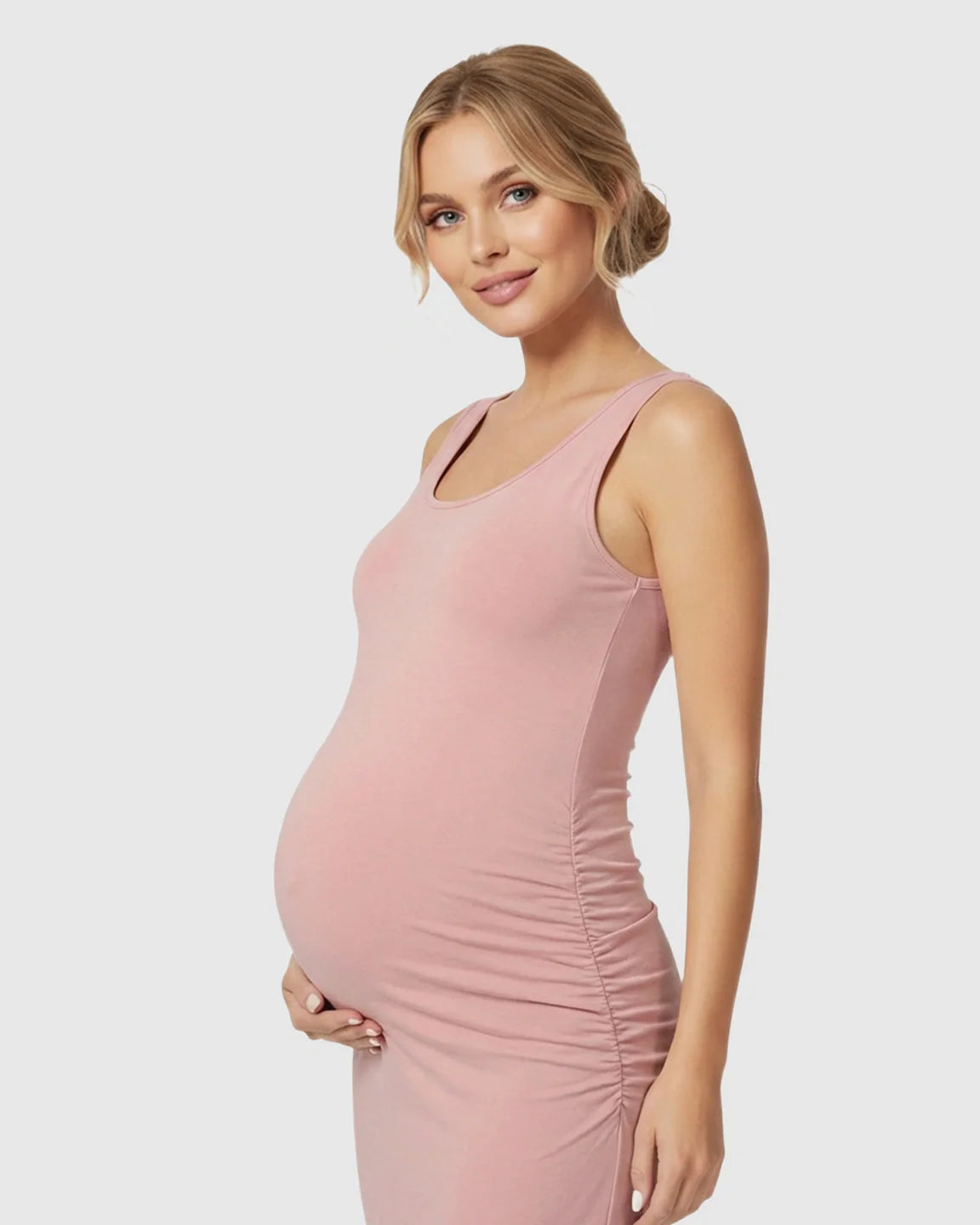 Pregnant woman in a pink sleeveless bodycon maternity dress with side ruching, highlighting her bump.