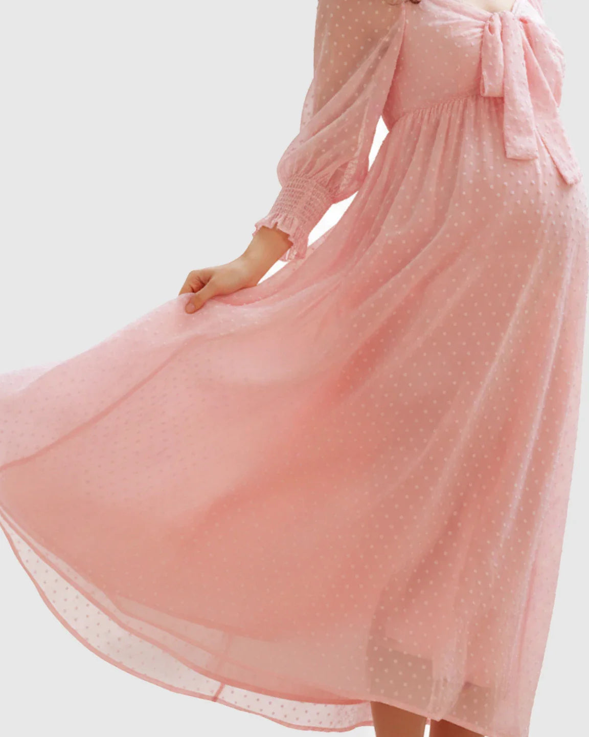 Pink polka-dot chiffon maternity maxi dress with long sleeves, square neckline, and bow detail.