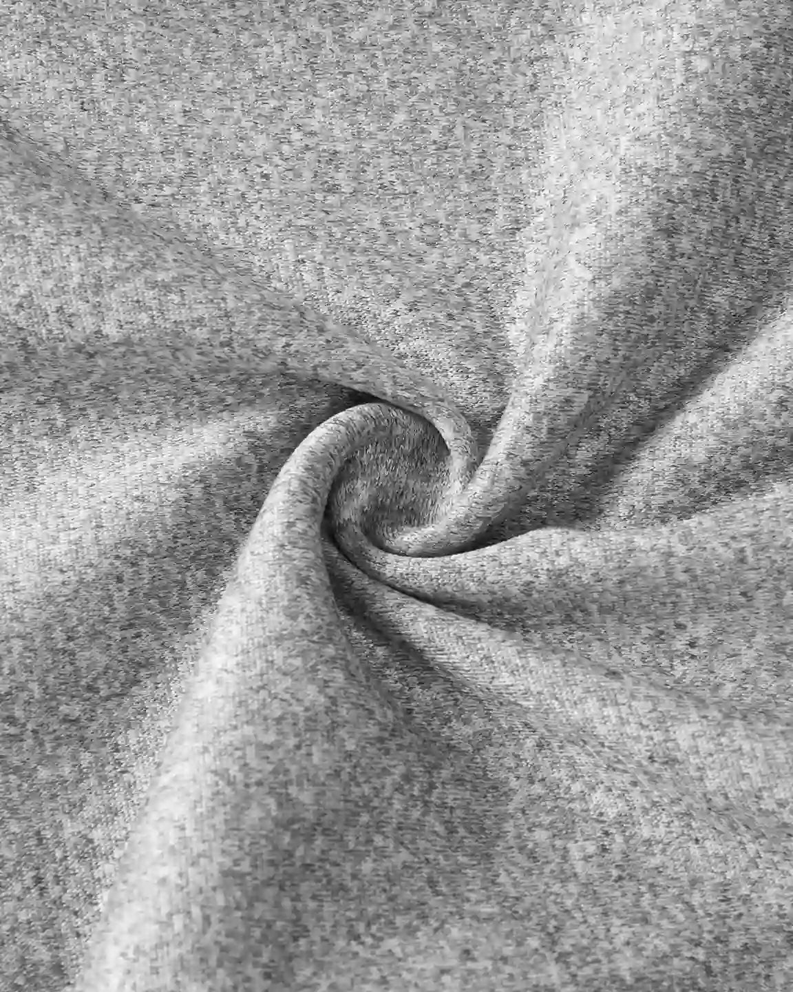 Close-up of soft, heather gray knit fabric, gently swirled to show its texture and stretch.