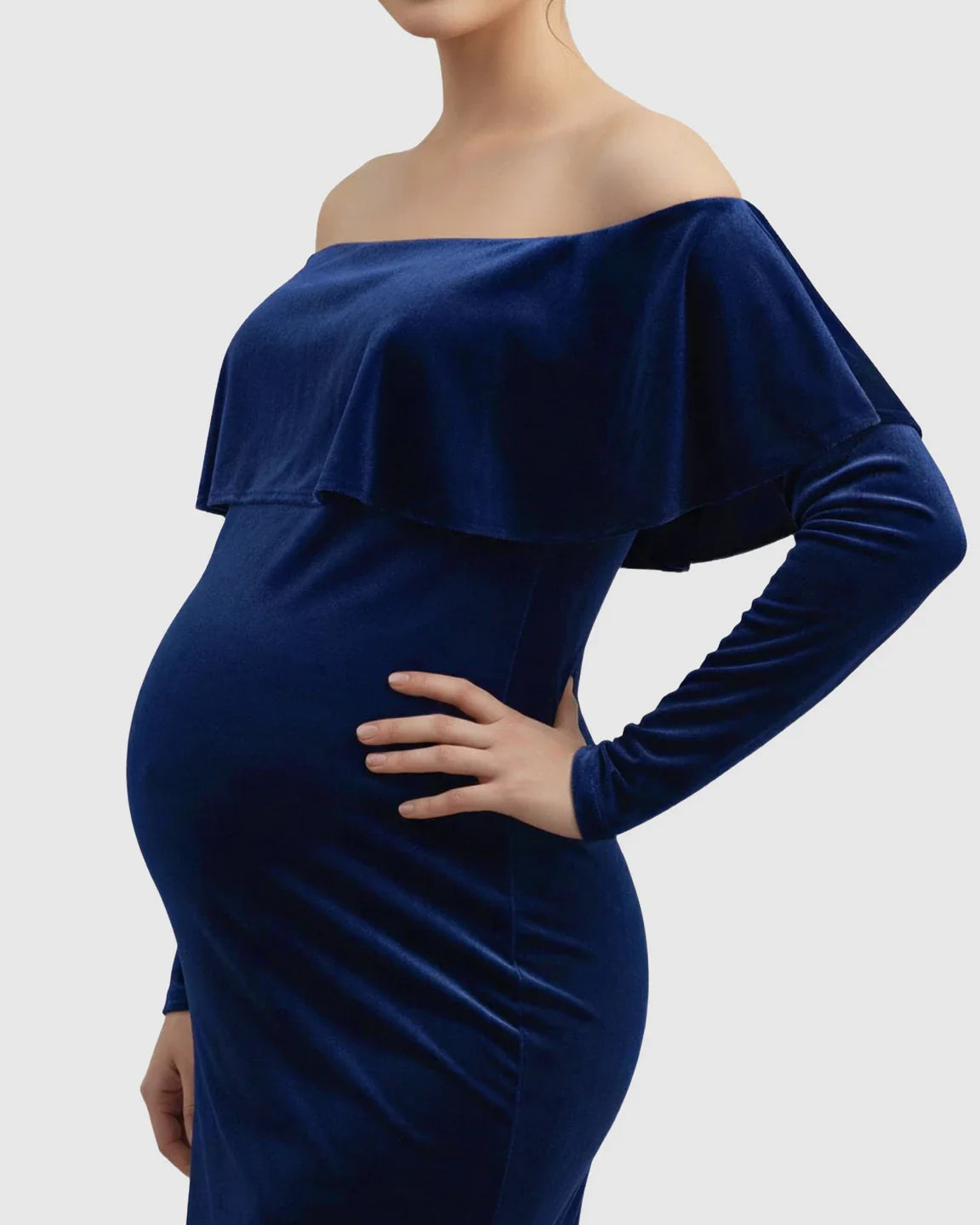 Navy velvet off-shoulder maternity photoshoot gown with long sleeves, highlighting the baby bump.