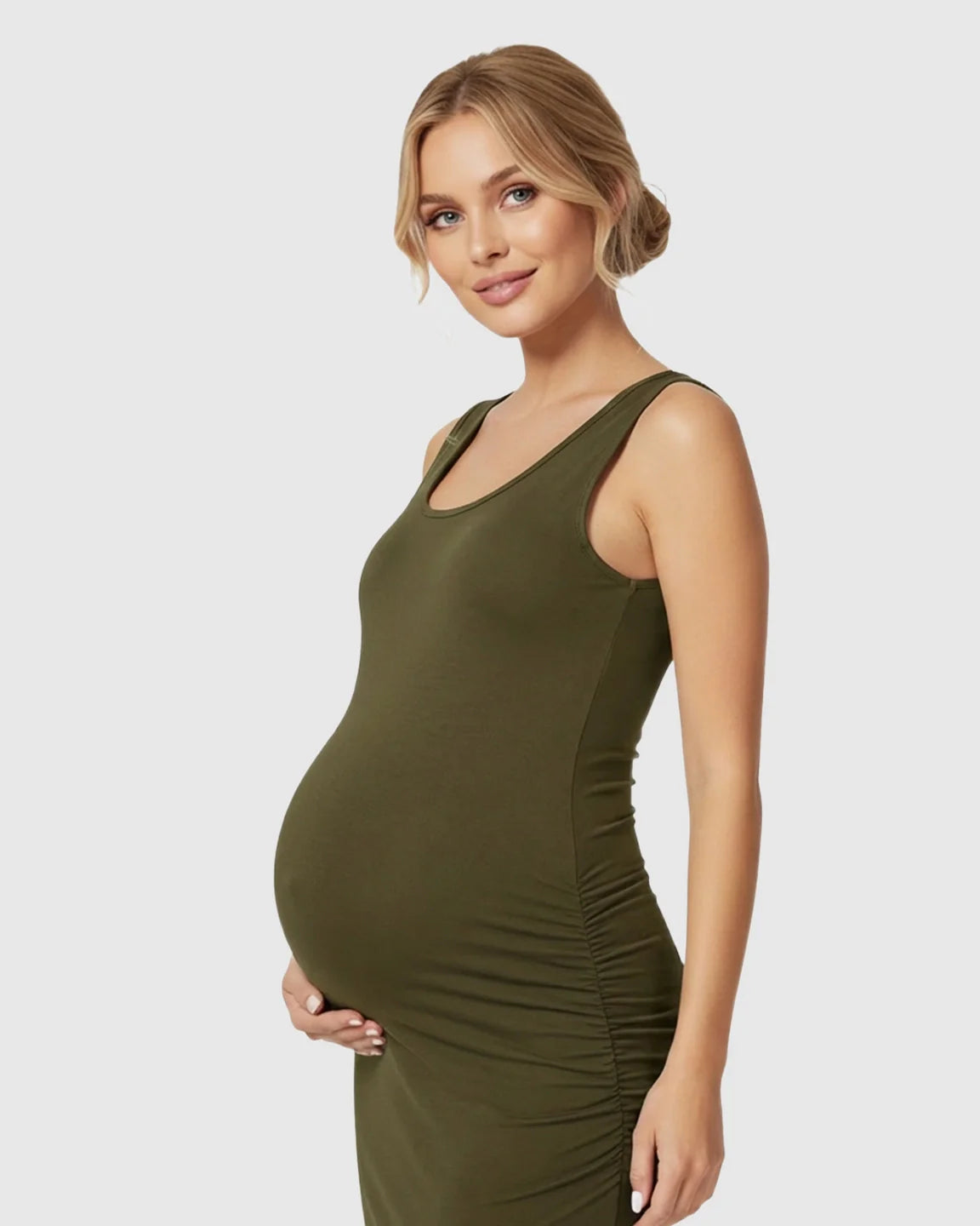 Pregnant woman in a sleeveless, olive green bodycon maternity dress with side ruching.