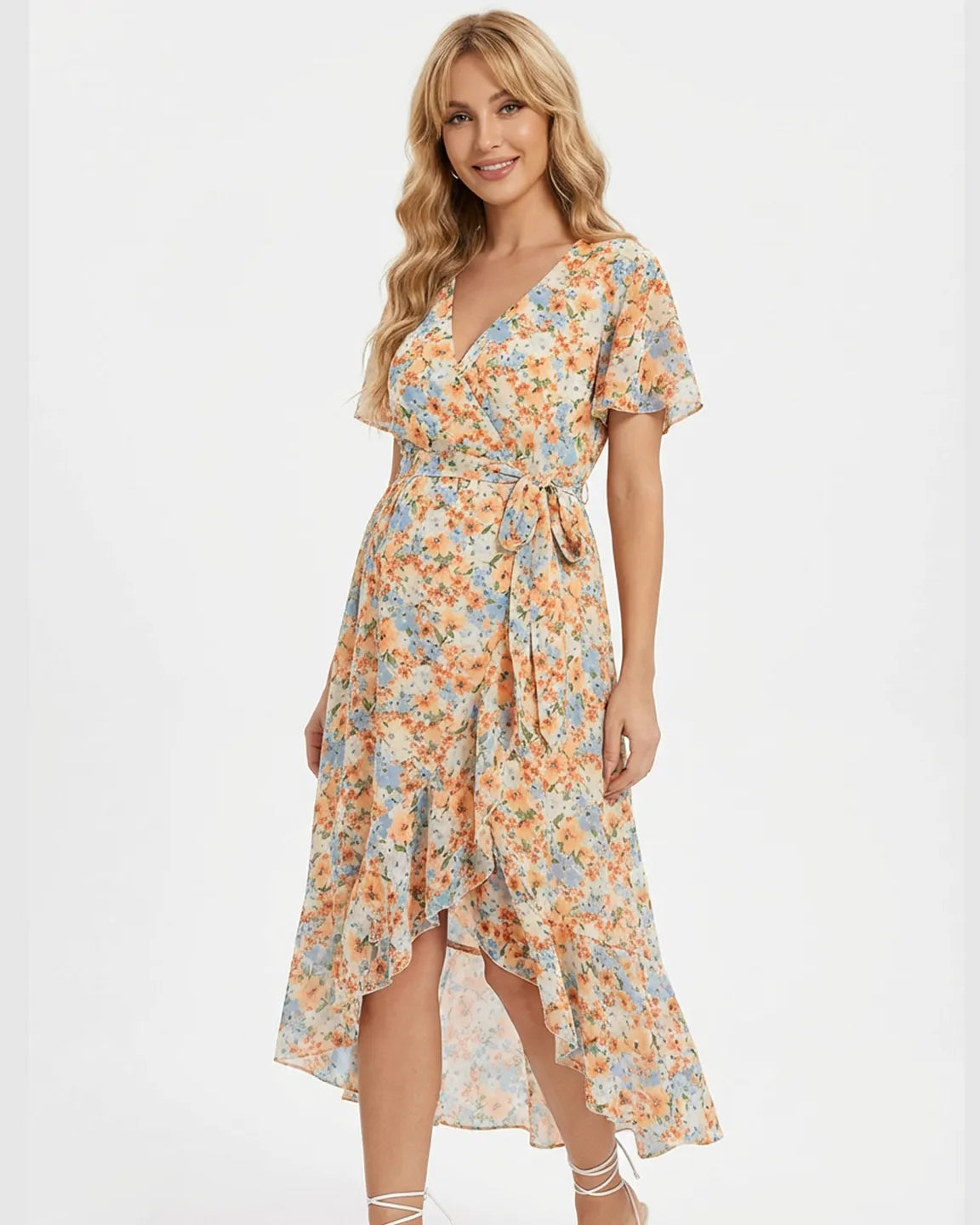 Smiling pregnant woman in a floral orange and blue V-neck ruffled hem maternity midi dress.
