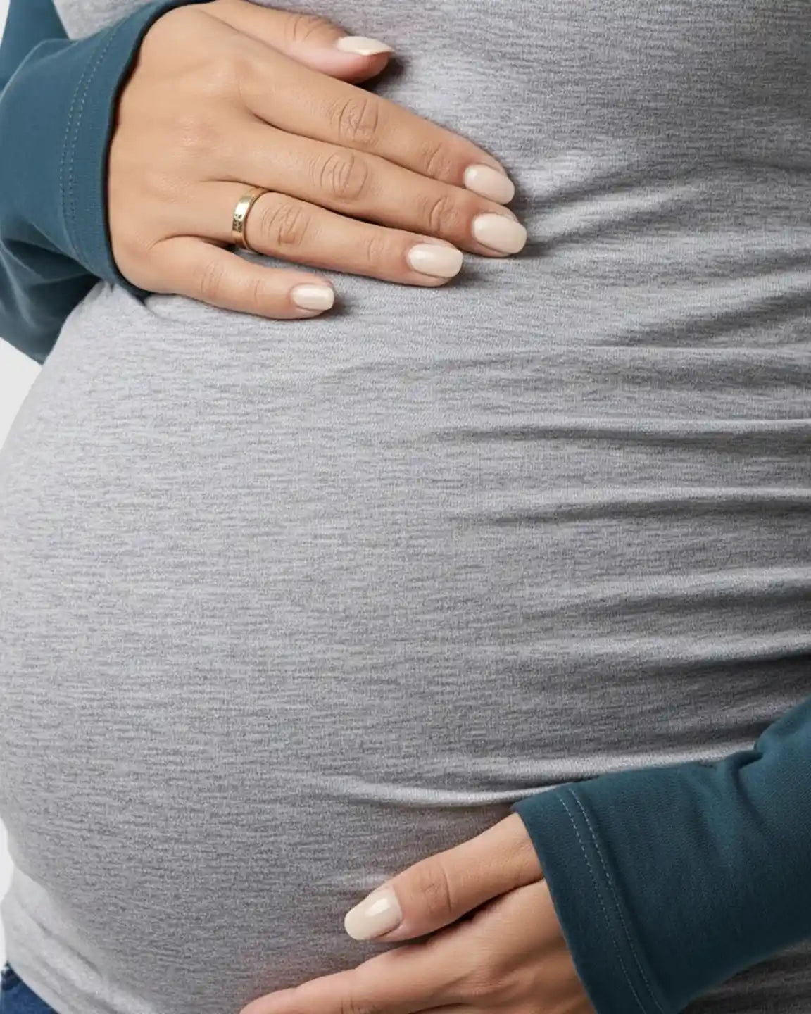 Maternity top in heather gray with teal raglan sleeves, featuring side ruching and a pregnant belly.