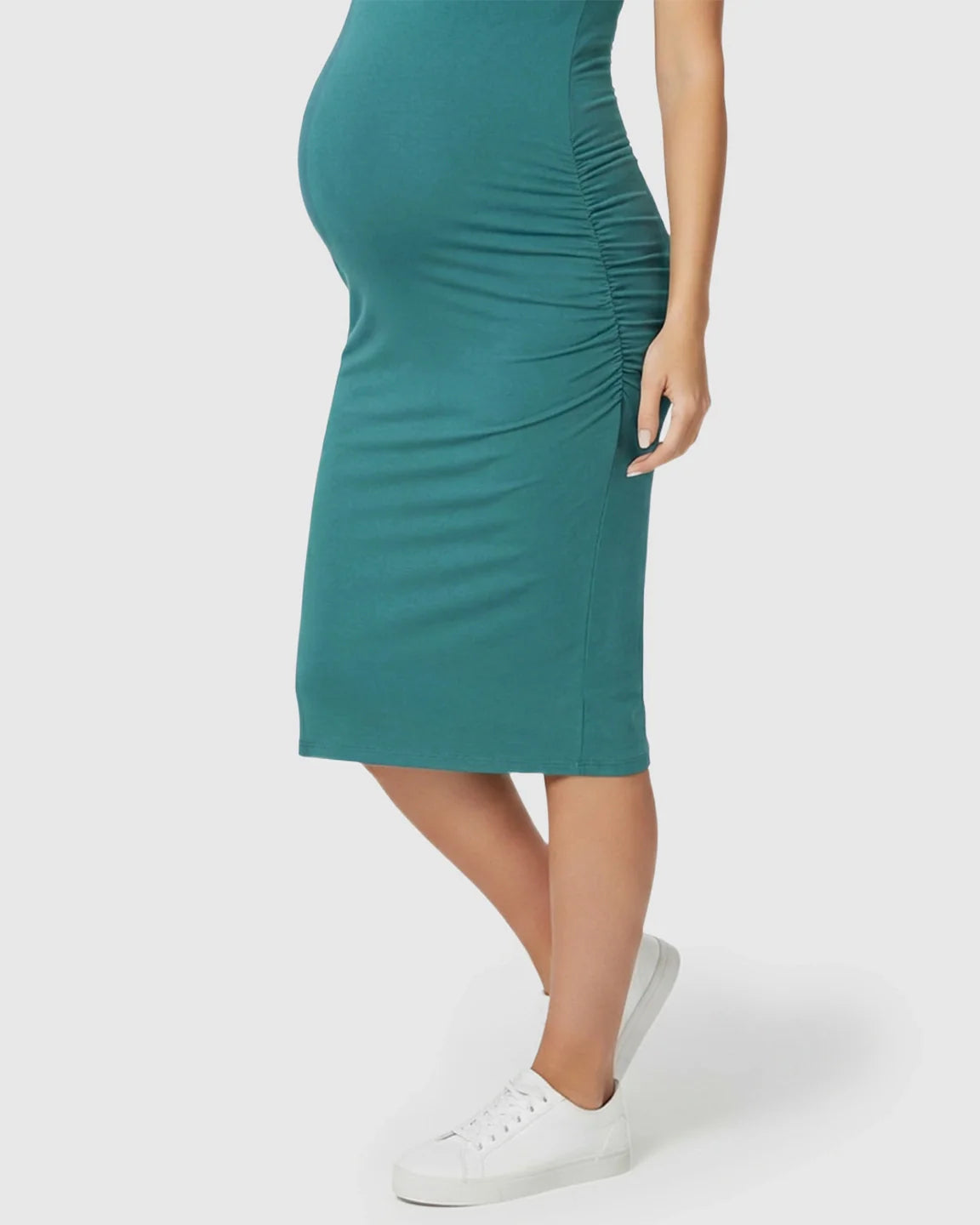Teal sleeveless bodycon maternity dress with side ruching, worn by a pregnant woman in white sneakers.