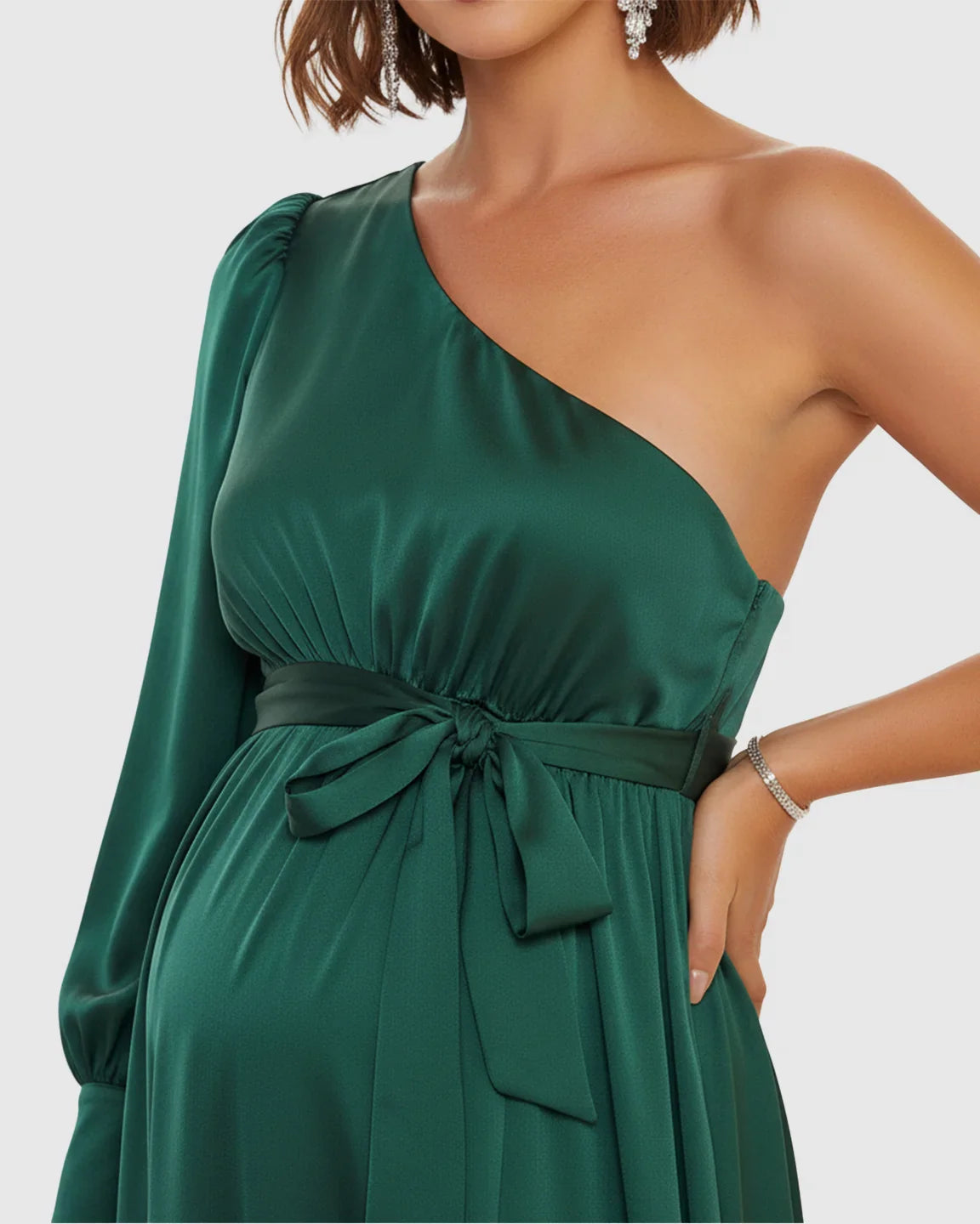 Elegant emerald green satin one-shoulder maternity maxi dress with a tie-waist and long sleeve.