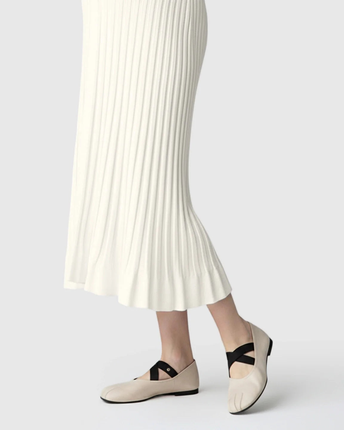 Cream ribbed knit maternity midi dress with long sleeves and a V-neck, paired with ballet flats.