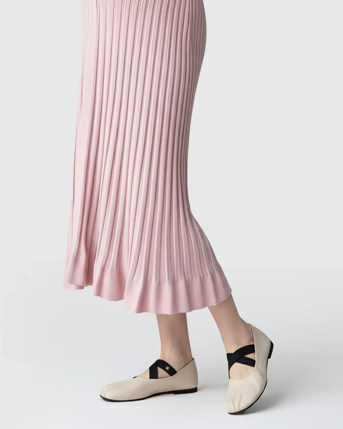 Pink ribbed knit maternity midi dress with a flared hem and beige ballet flats.