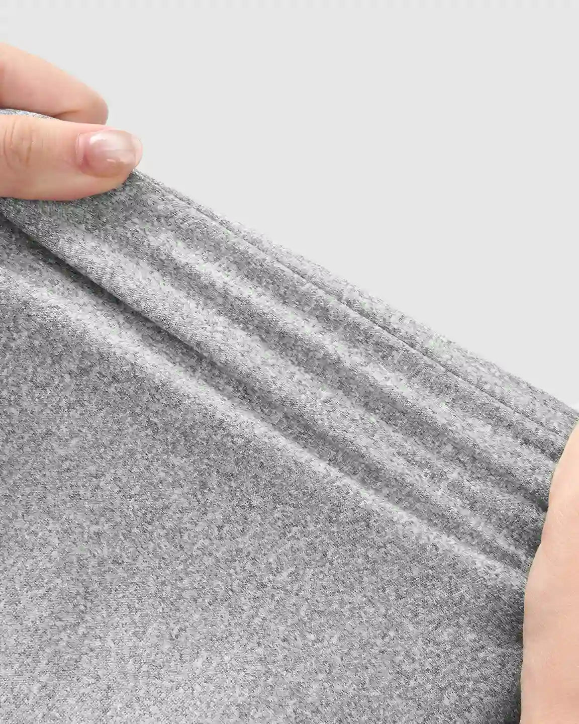 Hands stretching soft, heather gray maternity jogger fabric, highlighting its breathable, stretchy material.
