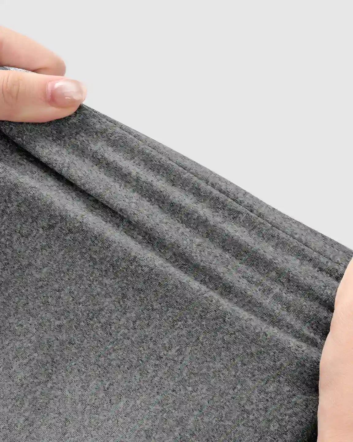 Hands stretching dark gray, soft, high-waist maternity jogger fabric, highlighting its breathable stretch.