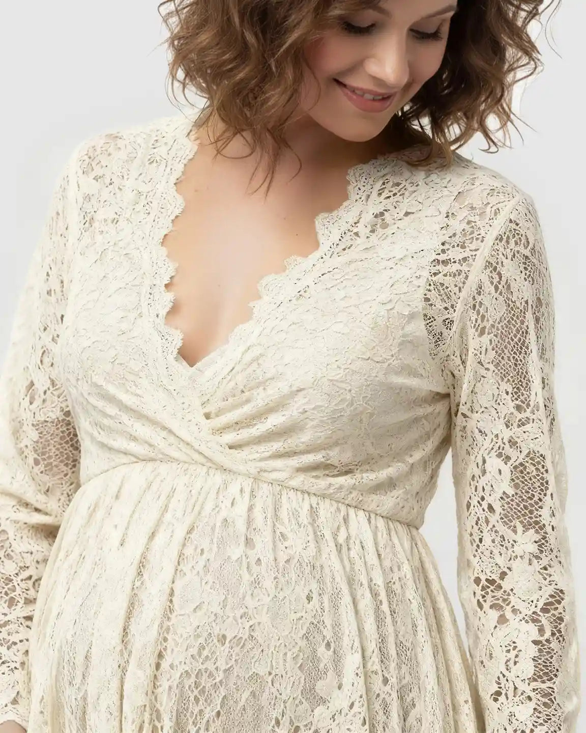 Maternity maxi dress in sheer floral lace, featuring an empire waist and long sleeves.
