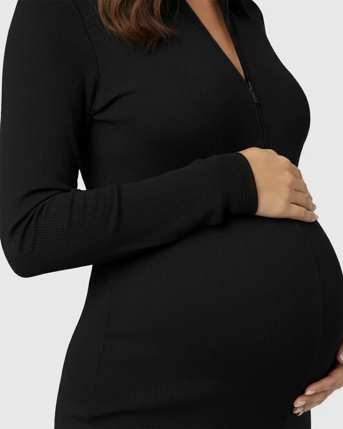 Black ribbed maternity jumpsuit with a zip-front, long sleeves, and a pregnant belly.