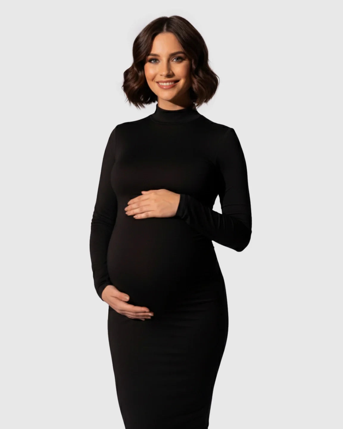 Smiling pregnant woman in a black mock-neck bodycon maternity maxi dress, hands on her bump.