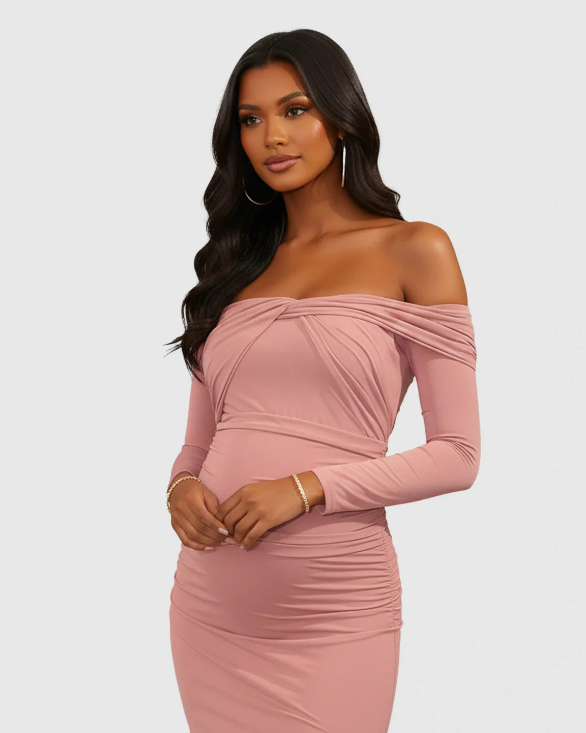 Woman in a pink ruched off-shoulder long-sleeve bodycon maternity photoshoot dress.