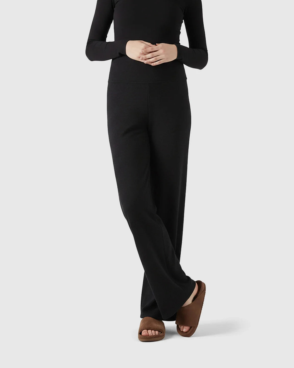 Black fleece relaxed maternity pants with over-belly waistband and wide-leg silhouette.