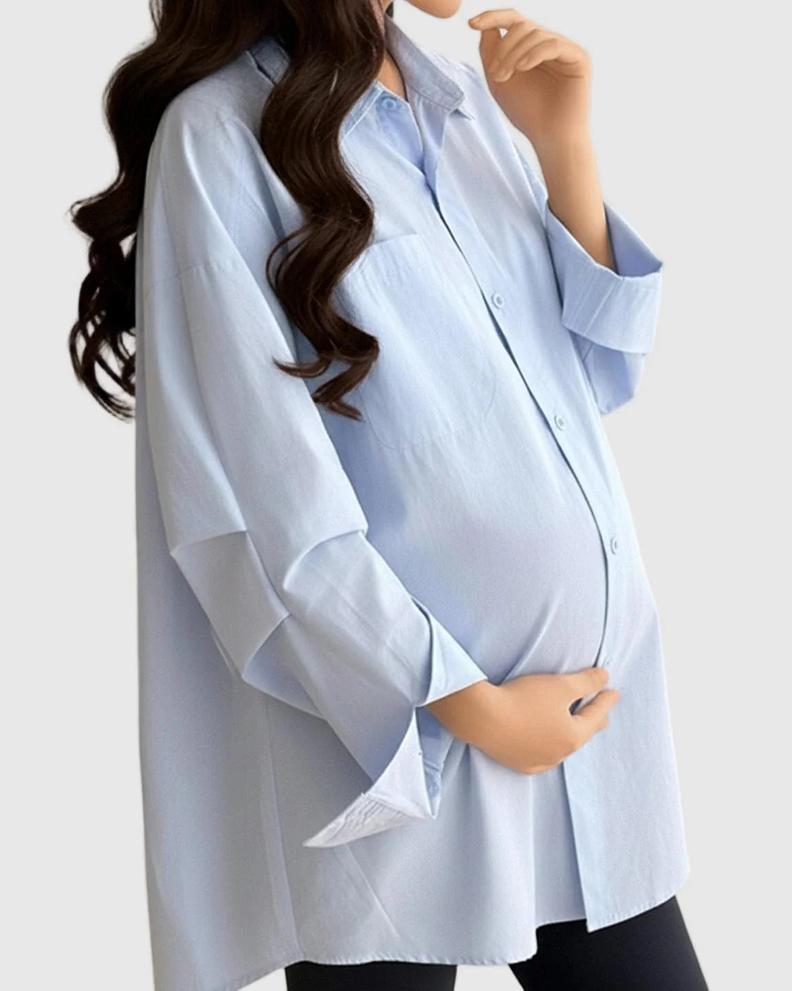 Pregnant woman in a light blue cotton lapel-collar button-front maternity tunic, long sleeves, relaxed fit.