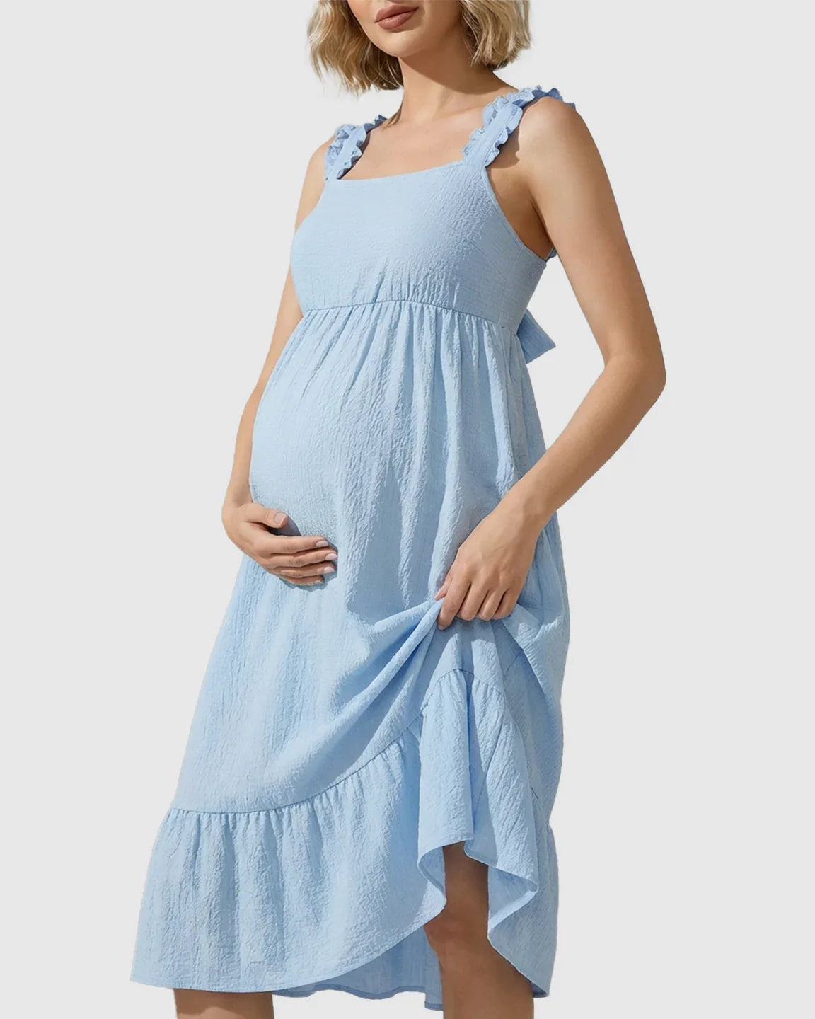 Pregnant woman in a light blue tiered maxi dress with ruffled straps and an empire waist.