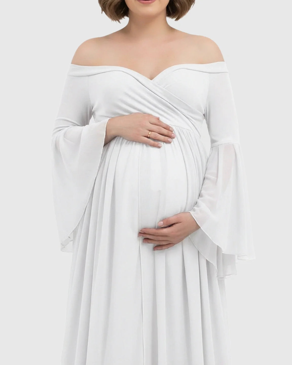 White off-shoulder maternity gown with bell sleeves and a flowing chiffon skirt.