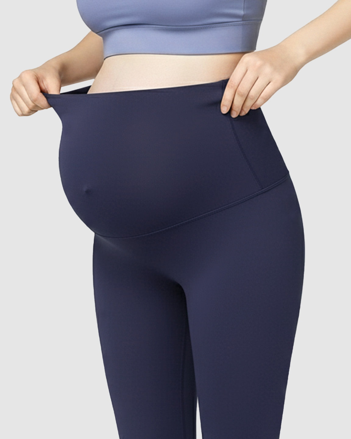 Pregnant woman wearing navy blue high-waist soft stretch maternity leggings, showing the comfortable bump support.