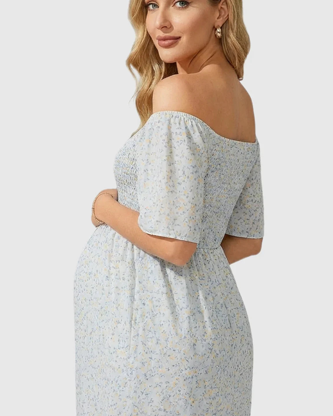 Maternity midi dress with light blue floral print, off-shoulder smocked top, flutter sleeves, and flowy skirt.