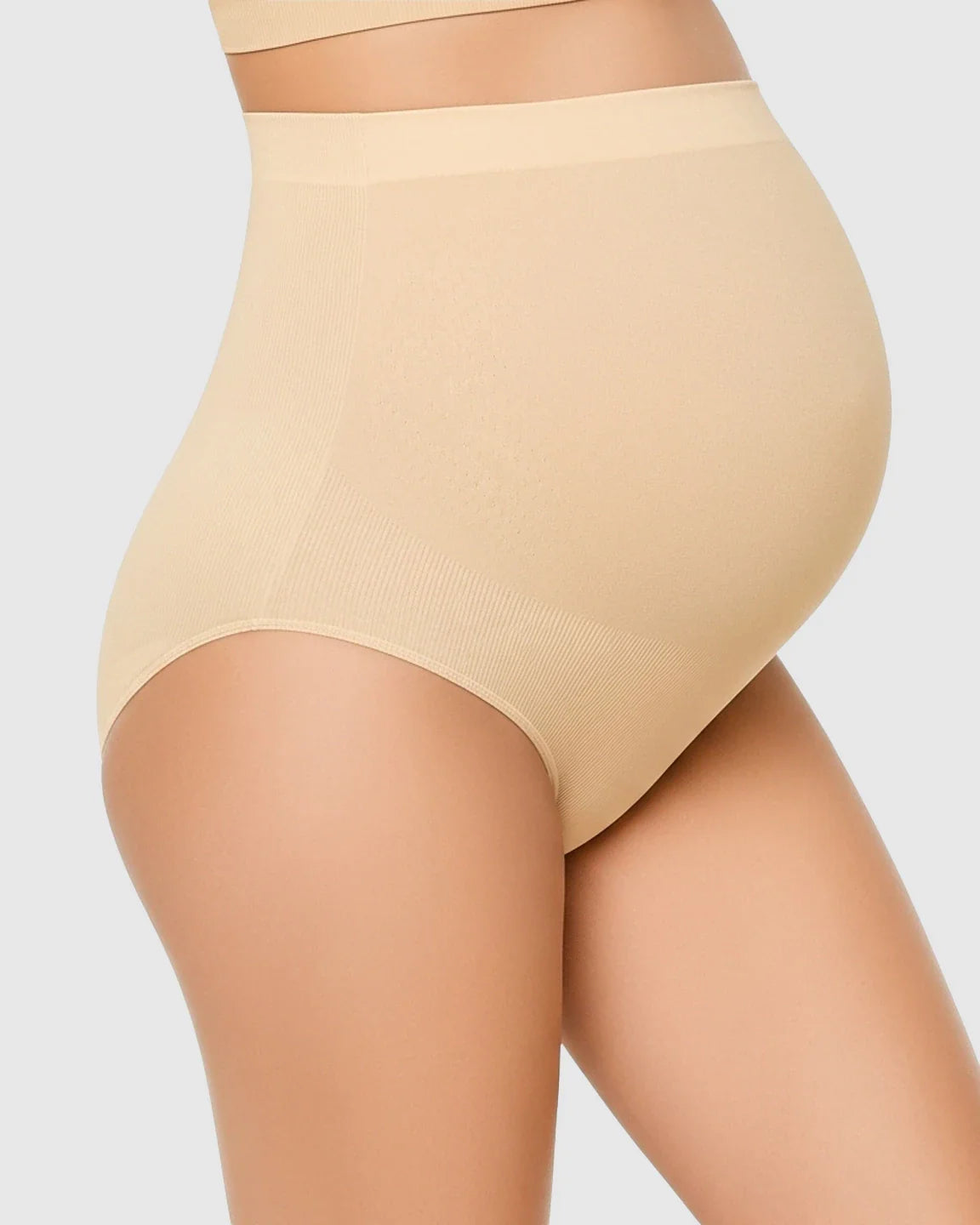 Nude high-waist seamless maternity underwear on a pregnant belly, offering gentle support and a smooth fit.
