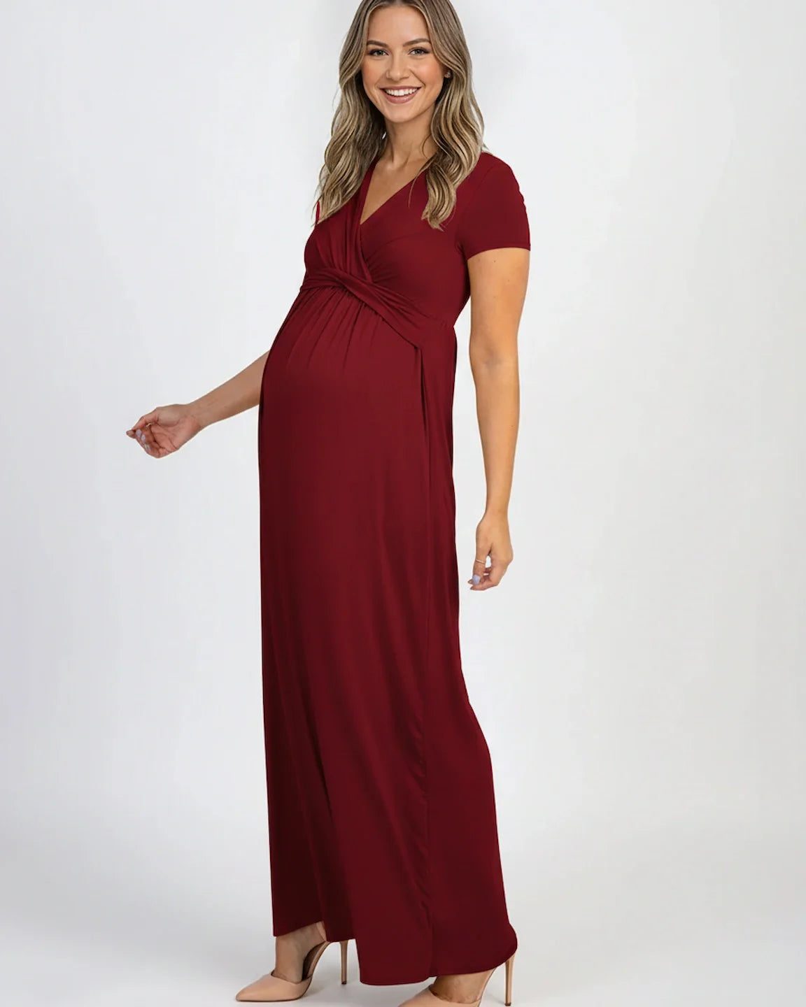 Smiling pregnant woman in a red Twist Front Draped Maternity Nursing Maxi Dress with short sleeves.