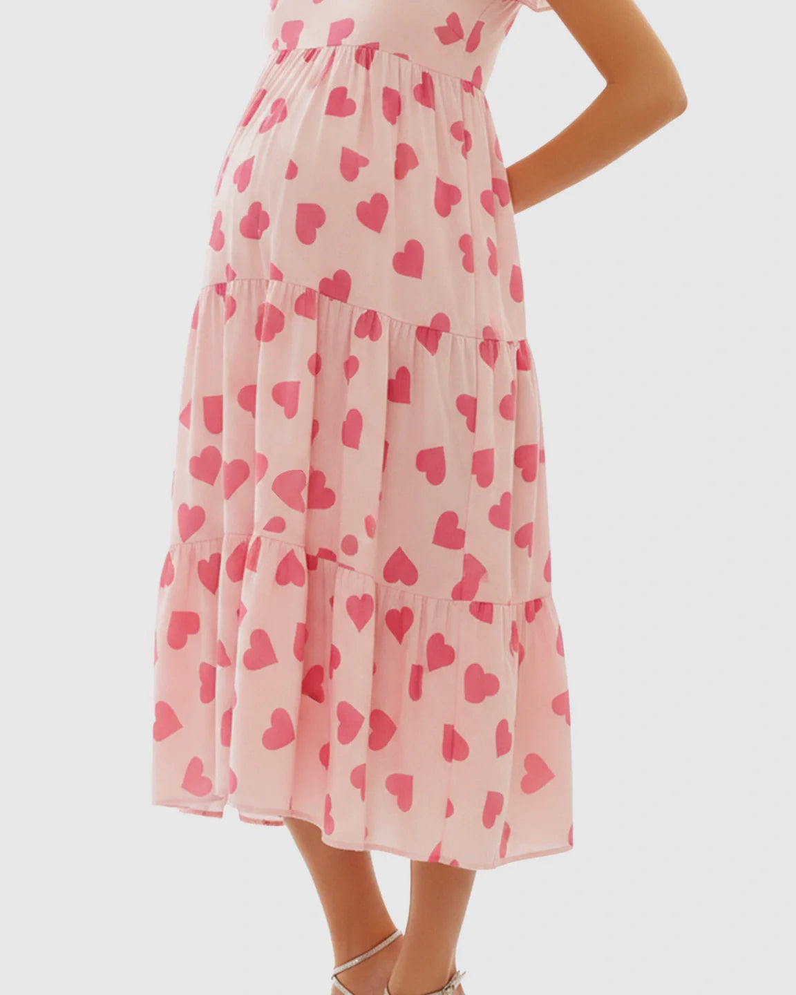 Pink chiffon maternity midi dress with tiered skirt and heart print, designed for comfort.