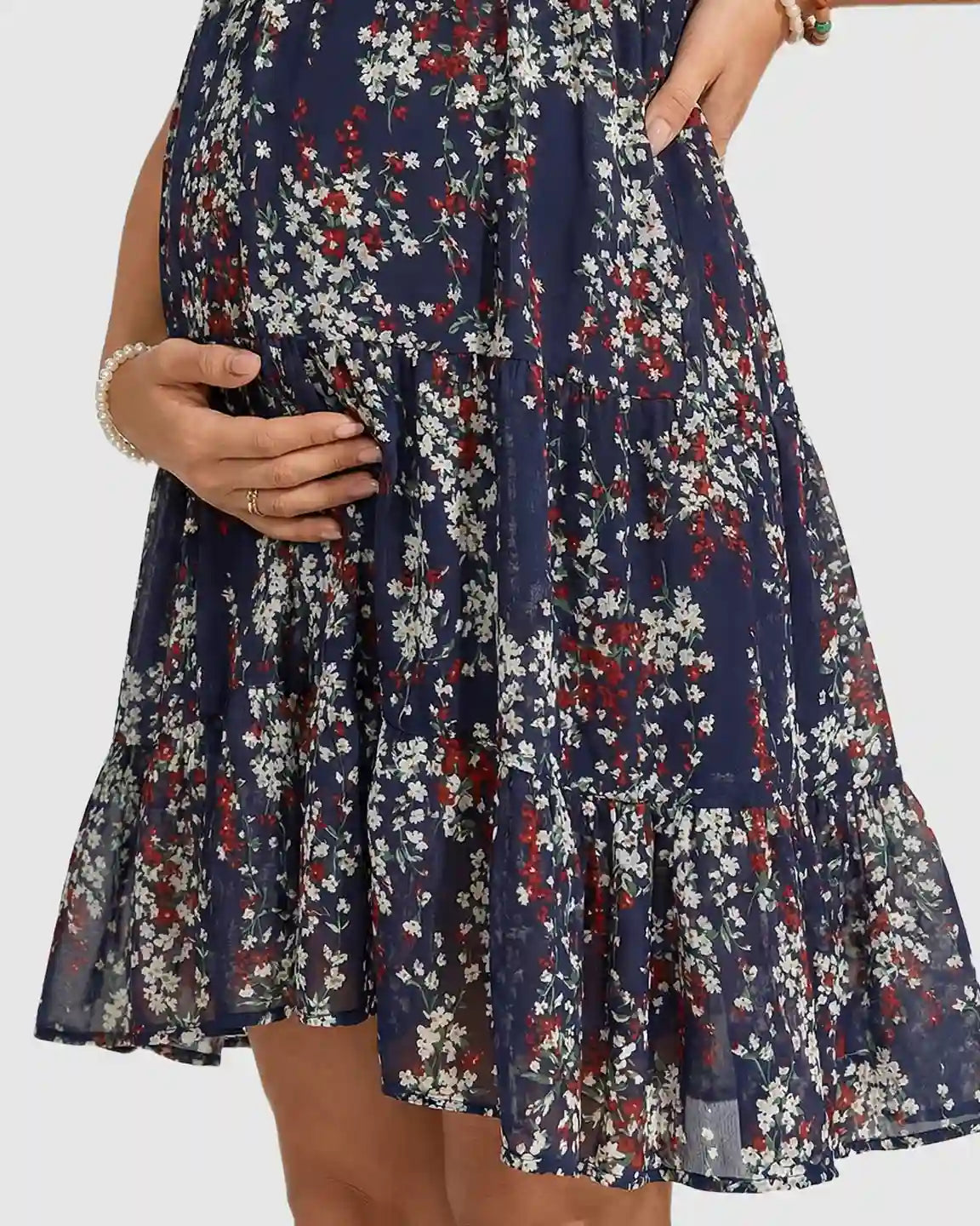 Navy chiffon maternity dress with white and red floral print, flutter sleeves, and tiered A-line skirt.