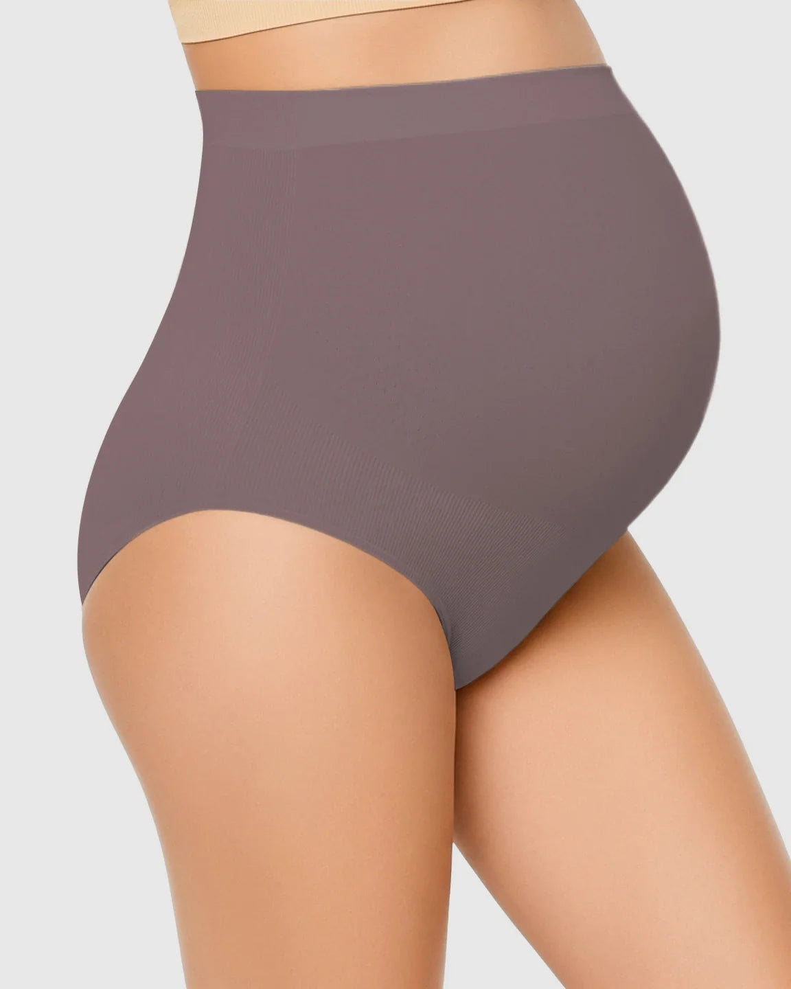 Maternity model wearing seamless, high-waist, mauve belly-support underwear.