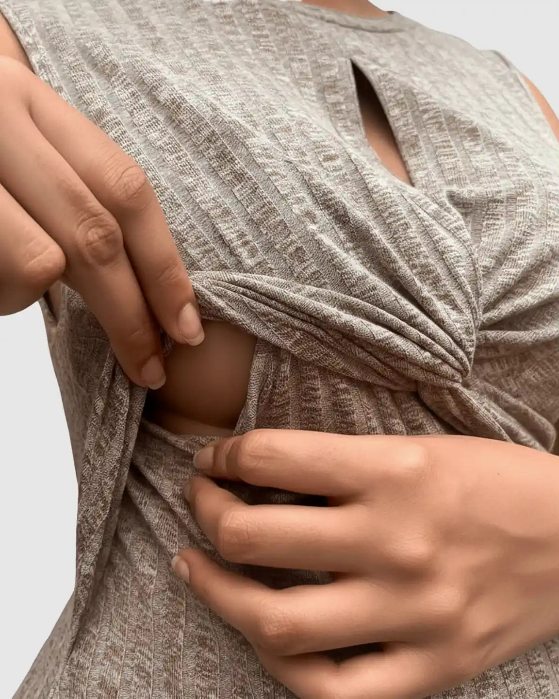 Woman's hands reveal the hidden nursing opening of a beige ribbed crisscross chest bodycon maternity dress.